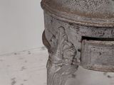 an old metal pot on a stand on the floor