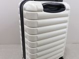 an image of a white suitcase with wheels on the floor
