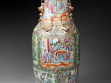 a vase with a painting on it sitting on a table