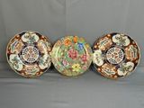 trois assiettes ornées de motifs différents, posées sur une surface grise