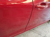 a close up of a red car with a broken door handle
