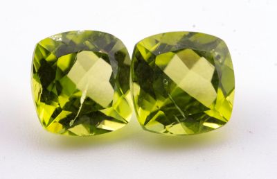 une paire de péridotites vertes sur une surface blanche