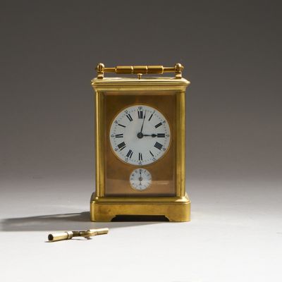 une horloge en or avec des chiffres romains et une clé