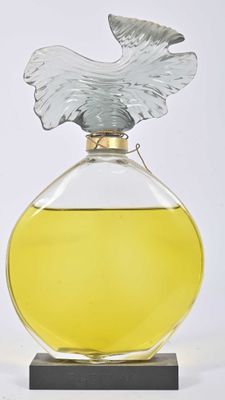 un flacon de parfum surmonté d'un oiseau