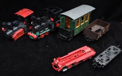 several toy trains are lined up on a black surface