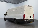 the back of a white van is parked in a large room