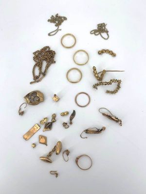 a group of gold rings and other jewelry on a white surface