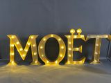the word moet is lit up with yellow light bulbs