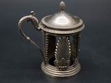 an antique silver teapot with a lid and handle on a black surface