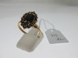 Gros plan sur une bague en or ornée d'une pierre noire