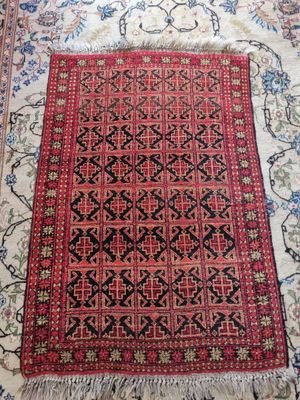 a red rug with black and white designs on it