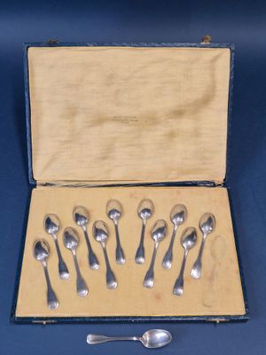six cuillères en argent dans une boîte contenant une cuillère