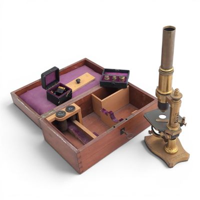 a wooden box with a microscope and other items in it