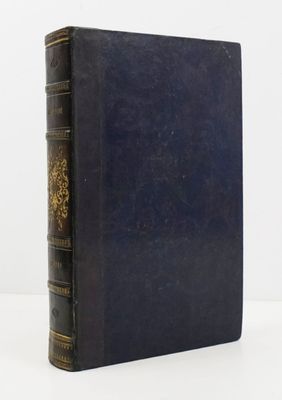 un vieux livre à la couverture bleue posé sur une table blanche