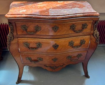 a small chest of drawers in a room with a radiator radiator