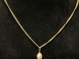 a gold necklace with a pearl pendant on a mannequin mannequin mannequin mannequin mannequin mannequin mannequin manne