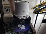 a white coffee pot sitting on top of a glass table