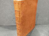 a brown leather book sitting on top of a gray surface
