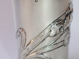 a silver cup with a flower design on it