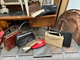 de nombreux sacs à main posés sur une table, avec un miroir en arrière-plan