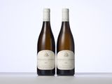 two bottles of wine sitting on top of a table next to each other