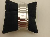 silver metal bracelet with black velvet pillow on white surface