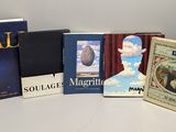 Plusieurs livres sont posés sur une étagère dans un coin de la pièce.