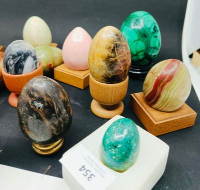 de nombreux œufs en marbre de différentes couleurs exposés sur une table
