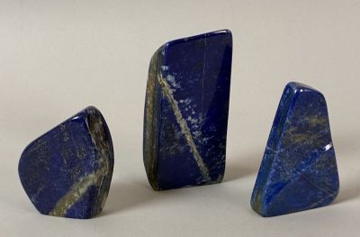 three pieces of lapis on a white surface with a white background