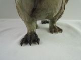a statue of an owl that is standing on a white surface
