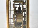 a small gold clock with a glass case on it