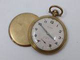 a gold pocket watch sitting on top of a white table
