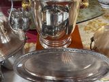 a silver plate with a silver cup on top of it