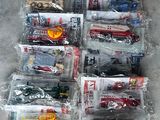 beaucoup de petits camions en plastique dans des sacs en plastique, par terre