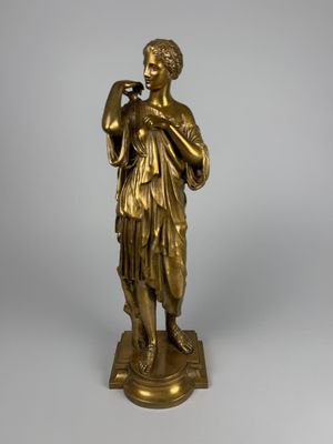 an antique bronze statue of a woman holding a bird on a pedestal