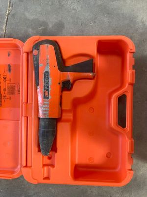 une boîte orange posée par terre, contenant un marteau