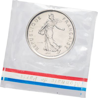 un gros plan d'une pièce de monnaie dans un sachet en plastique sur fond blanc
