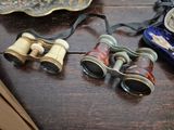two pairs of binoculars sitting on a table next to a plate