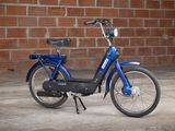 a blue bike parked in front of a brick wall