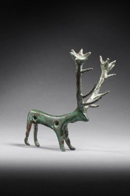 a close up of a bronze statue of a deer with birds on it