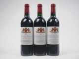 three bottles of red wine sitting next to each other on a white surface
