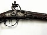un vieux pistolet accroché à un mur, sur fond blanc