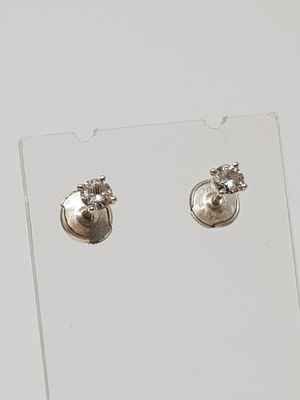 pair of silver plated earrings on clear acrylic stand