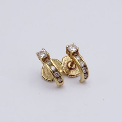 une paire de boucles d'oreilles en or et diamants sur fond blanc