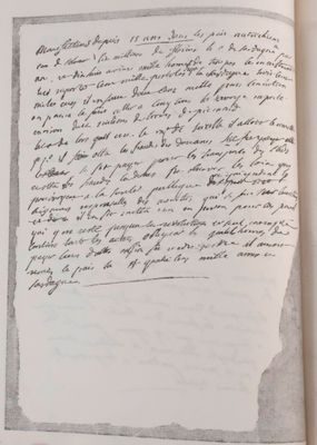 an open book with a handwritten letter on it sitting on top of a table