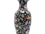 a black vase with colorful flowers on it on a white background