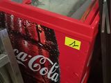 a red cooler sitting next to a refrigerator in a room