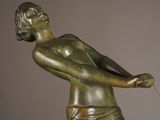 bronze statue of a boy holding a tennis racquet on a marble base