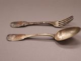 two spoons and a fork sitting on a table