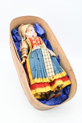 a doll in a wooden box with a blue cloth